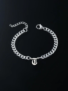 Silver Cuban link bracelet featuring a gothic letter J pendant on reflective black surface