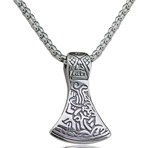 Detailed macro view of a vintage Viking axe pendant with ornate Nordic carvings