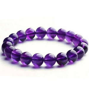 Macro detail of natural translucent purple amethyst beads on a round beaded bracelet