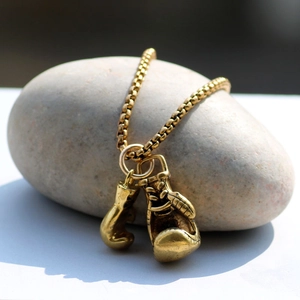 Collana con ciondolo guantoni da pugilato in oro vintage con catena su pietra grigia