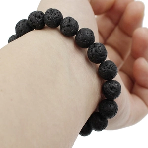 Porous black lava stone bead bracelet with natural matte texture on a wrist