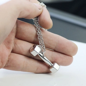 Detailed hand-held view of a silver dumbbell pendant necklace for fitness lovers
