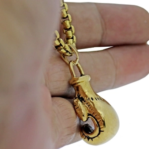 Makroaufnahme von Boxhandschuh-Anhänger in Gold mit schwarzer Gravur an Boxkette