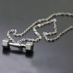 Macro view of gunmetal dumbbell pendant with high-quality metal texture on link chain