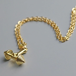 Gros plan détaillé du pendentif haltère doré pour collier de fitness pour femmes
