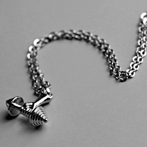 Détail macro du pendentif haltère argenté avec texture précise pour les sportifs