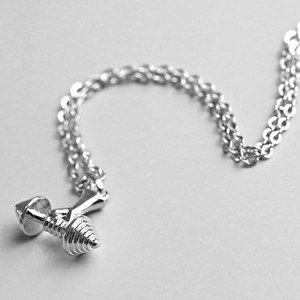 Gros plan d'un collier pendentif haltère en argent poli pour bijoux de fitness femme