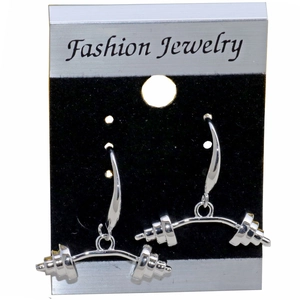 Macro detail of silver-colored barbell earrings hanging on a display jewelry card