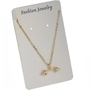 Golden fitness necklace with dumbbell pendant displayed on a fashion jewelry white card