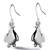 Gros plan détaillé de jolies boucles d'oreilles pingouin en argent avec fini métal poli