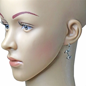 Vue détaillée d'une boucle d'oreille haltère en argent sur un modèle pour style fitness