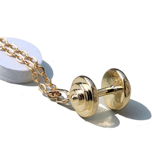 Collier avec pendentif haltère doré poli pour femme sur support d'exposition blanc