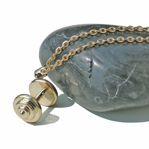 Collier avec pendentif haltère doré poli sur pierre avec fond blanc épuré