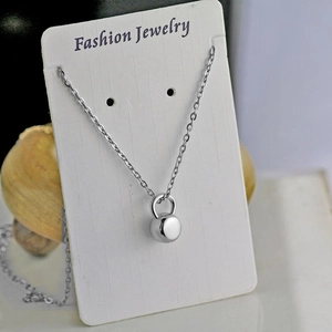 Detail of silver kettlebell pendant on fashion jewelry display card with chain