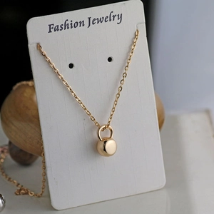 Detail view of a gold-plated fitness dumbbell pendant necklace on a jewelry display card