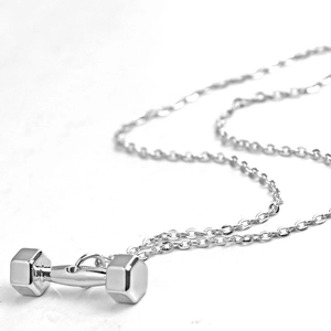 Nahaufnahme des polierten Hantel-Anhängers an einer O-Kette für Fitness-Schmuck