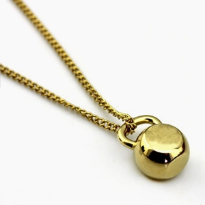Golden kettlebell pendant necklace for women with polished fitness charm on thin chain