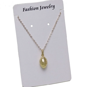 Detailed view of a golden 3D rugby ball pendant on a delicate O-chain necklace