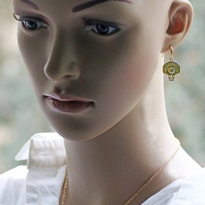 Detail of gold basketball hoop earrings and matching necklace worn on a model