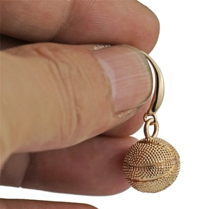 Vue macro de la boucle d'oreille basket dorée avec surface texturée et lignes noires