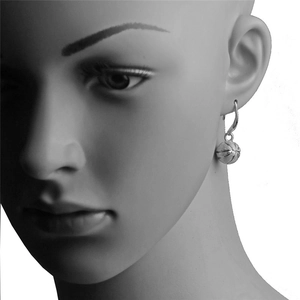 Boucles d'oreilles basket argentées avec textures détaillées sur un mannequin