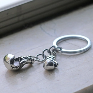 Detail of silver boxing glove keychain charms with realistic metal texture and key ring