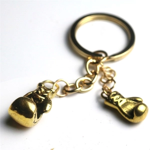 Vue macro de pendentifs gants de boxe dorés sur un porte-clés en métal avec anneau plat