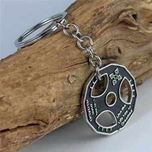 Barbell weight plate keychain with motivational quotes on a rustic wood background
