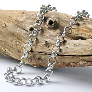 Detail of silver rolo chain necklace with polished finish wrapped on a wooden prop