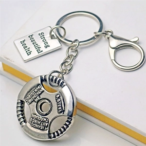 Gym weight plate keychain with engraved slogan and lobster clasp on white background