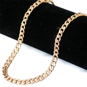 Detail of a 3.2mm rose gold Cuban link chain displayed on a black cylindrical jewelry stand