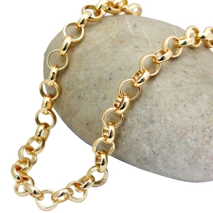 Detailed view of polished golden stainless steel link chain on a natural stone background