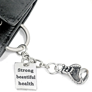 Nahaufnahme von Boxhandschuh-Schlüsselanhänger mit graviertem Strong Beautiful Health Anhänger