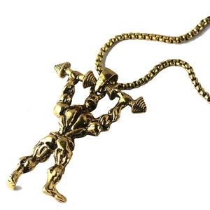 Detailed close-up of a golden bodybuilding pendant necklace for men featuring a lifelike muscular figure