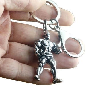 Detail view of antique silver muscular man charm on a metal keychain with spring hook