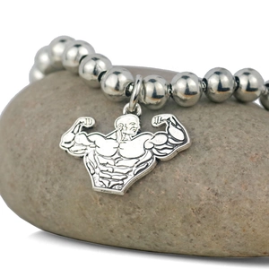 Vue macro d'un bracelet en perles d'acier avec pendentif culturiste sur une pierre