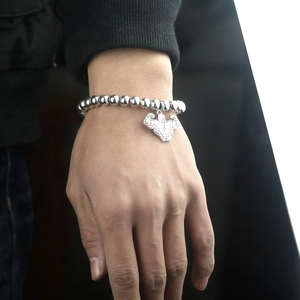 Vue détaillée du bracelet en perles d'acier argenté avec un pendentif de musculation