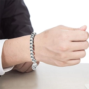 Détail du bracelet perlé en acier inoxydable pour homme avec breloque sport gravée