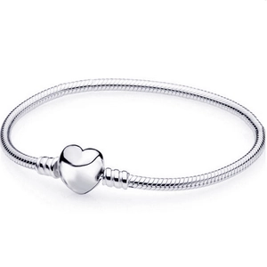Detail of silver snake chain bracelet featuring a polished heart-shaped clasp closure
