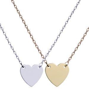Detail of high-polished heart-shaped pendants in silver and gold on fine link chains