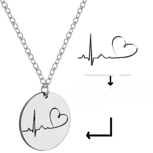 Detailed view of polished stainless steel round pendant with heartbeat line engraving