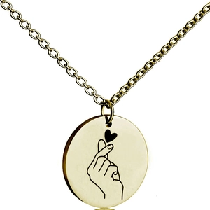 Detailed view of golden round pendant featuring a laser engraved heart hand gesture