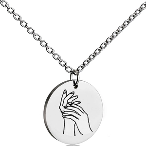 Macro shot of silver stainless steel round pendant featuring hand-drawn art engraving
