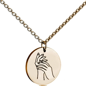 Close-up of a golden circular pendant necklace featuring a minimalist hand-holding line art
