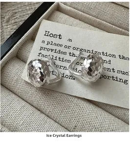 Macro shot of 925 sterling silver hoop earrings with a faceted crushed ice texture design