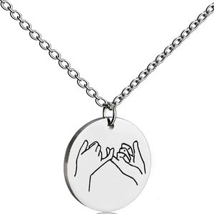 Macro shot of silver stainless steel round pendant featuring engraved pinky promise gesture