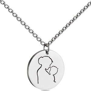 Macro shot of silver-tone circular pendant with mother and child silhouette engraving
