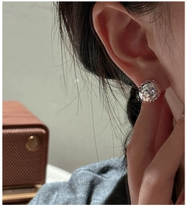 Close-up of sparkling faceted silver stud earrings worn on model for a minimalist look