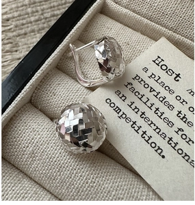 Macro shot of 925 sterling silver hoop earrings with geometric diamond-cut spherical surface