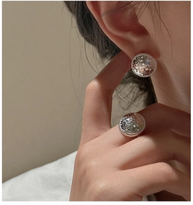 Macro view of S925 silver earrings with crushed ice texture and beaded edges on model